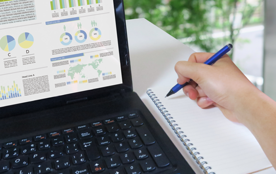 SEO分析チャート画面とメモを取る手